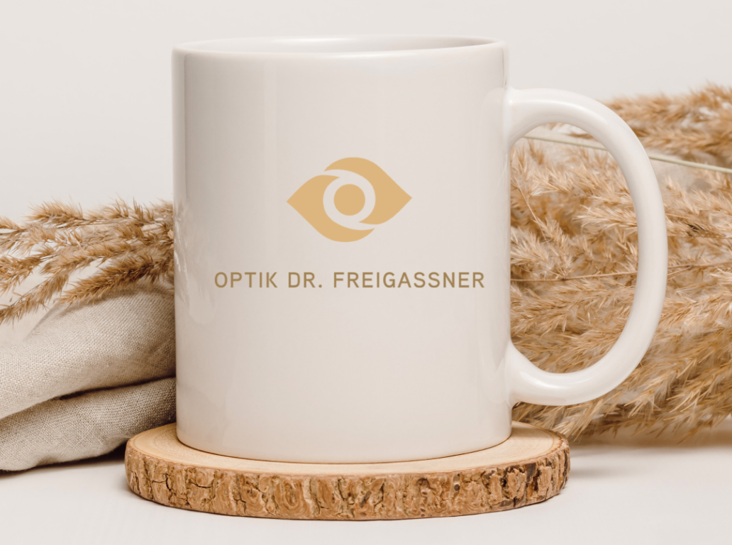 Tasse mit dem Optik Dr. Freigassner Logo.